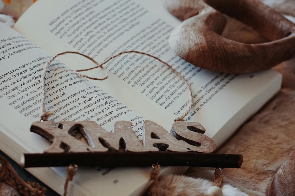A wooden “Xmas” decoration on top of a Greek book